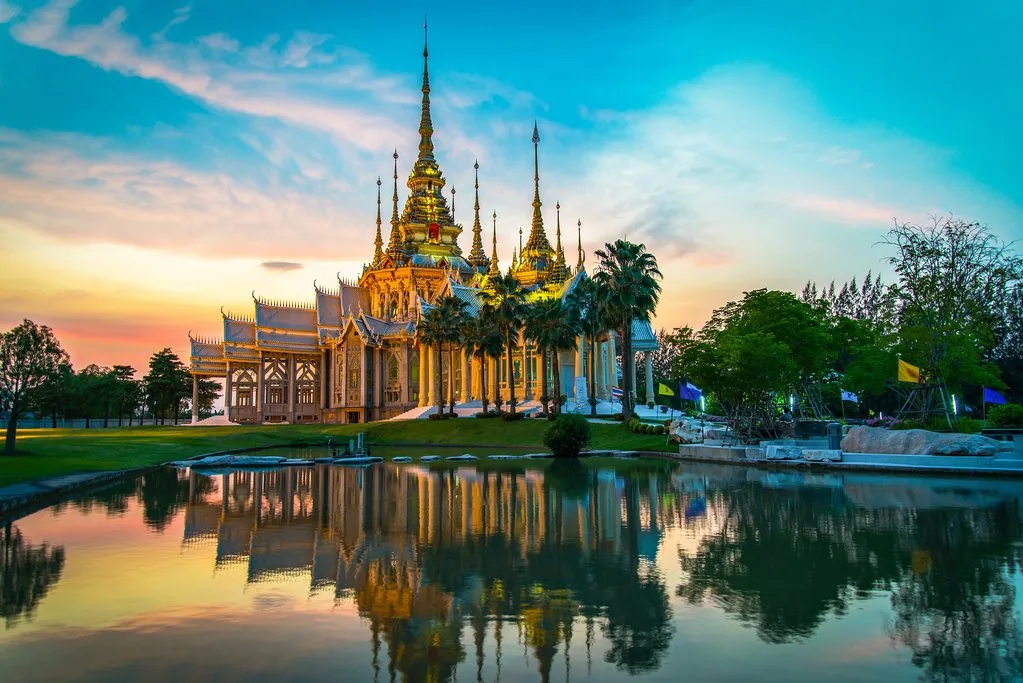 Thailand – golden temple reflected in a tranquil pond at sunset